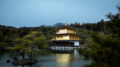 Free Golden Kinkaku-ji Temple reflected on serene pond in Kyoto, Japan's tranquil landscape. Stock Photo