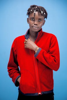 Portrait of an adult man in a red jacket against a blue background.