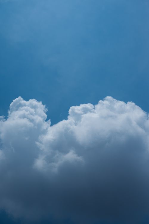 Free Tranquil sky with fluffy white clouds against a bright blue backdrop, perfect for nature and weather themes. Stock Photo