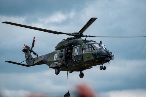 Free Military helicopter flying through cloudy skies during a training exercise. Stock Photo