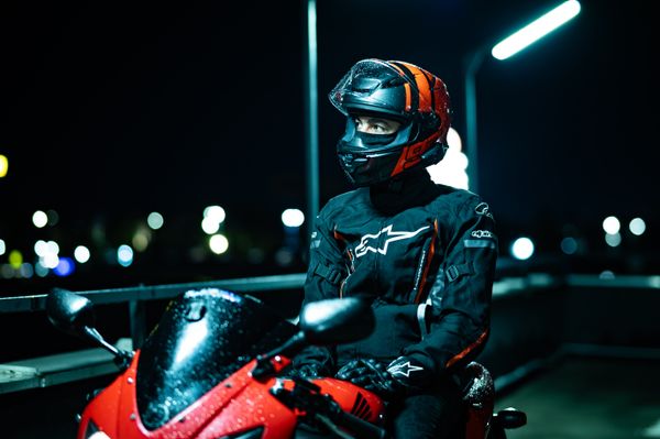 Motorcyclist in gear sitting on a parked bike, Marius Gabriel on Pexels