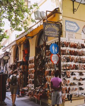 A vibrant street market in Athens, Greece featuring colorful displays of sandals.