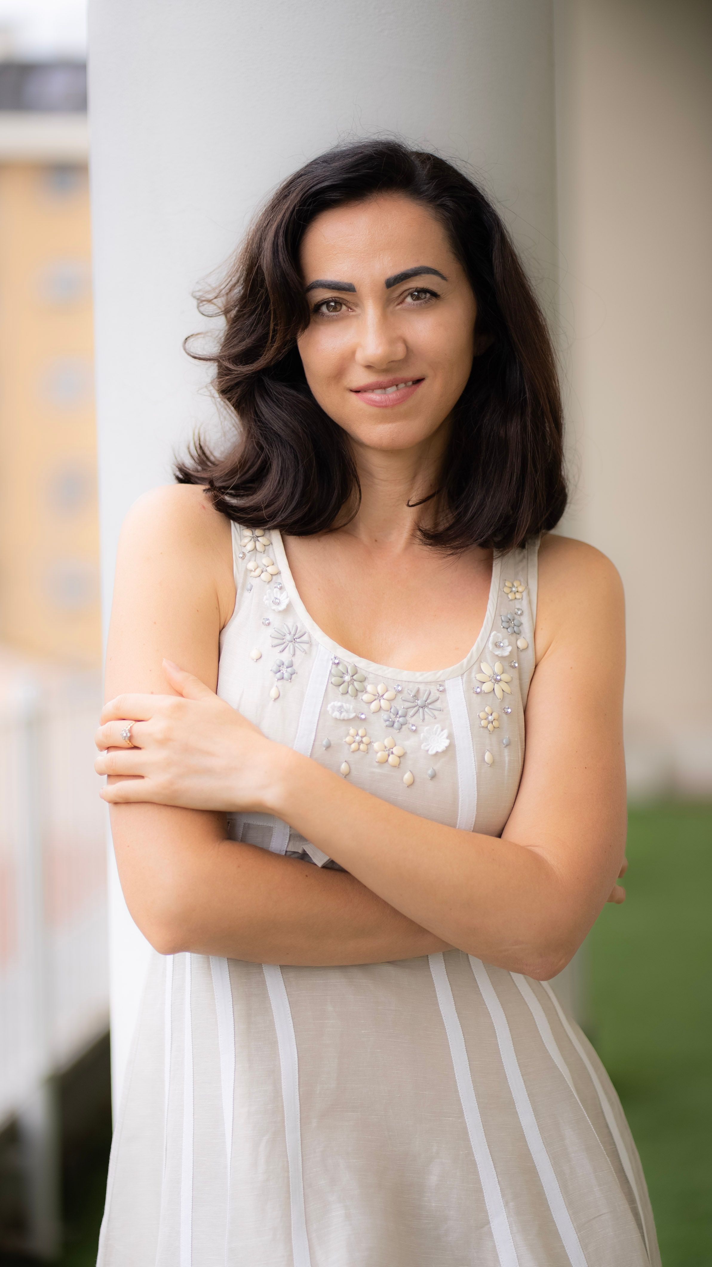 Elegant woman in a stylish dress posing outdoors in Milan, Italy.