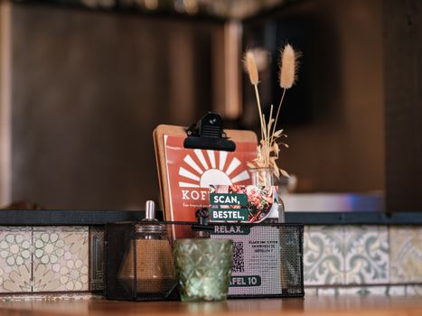 Inviting cafe table with rustic decor, menu card, and ambient candlelight in a cozy restaurant.