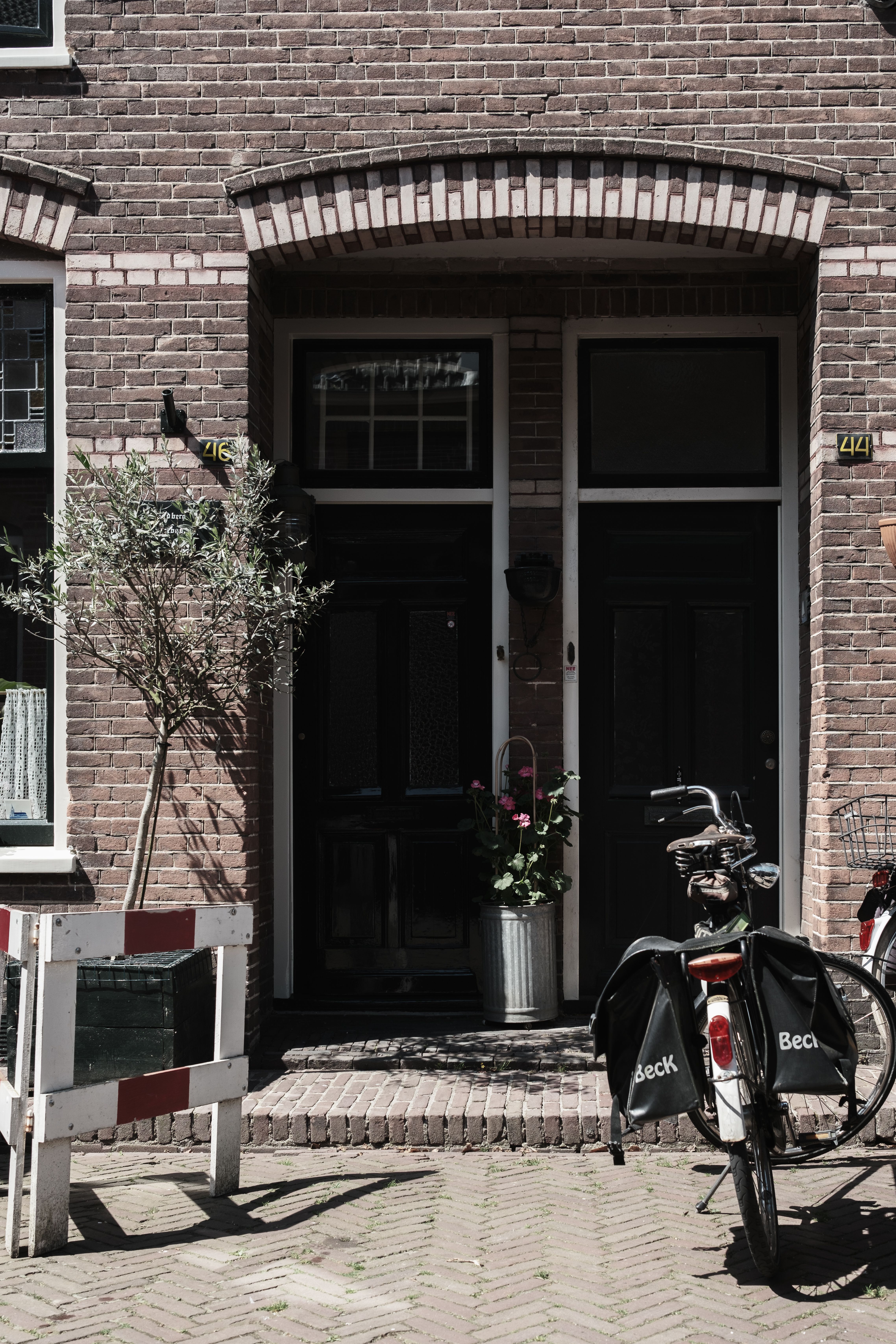 Quaint Dutch architecture with a bicycle and plant outside a charming brick entrance in Naarden.