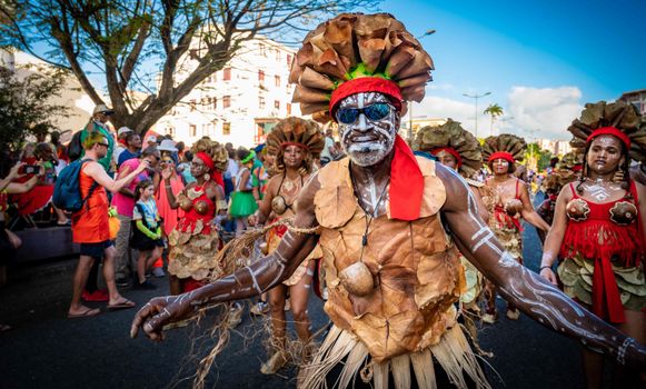 A lively carnival parade featuring participants in colorful, traditional costumes.