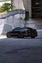 Sleek Black Sports Car Under Urban Bridge