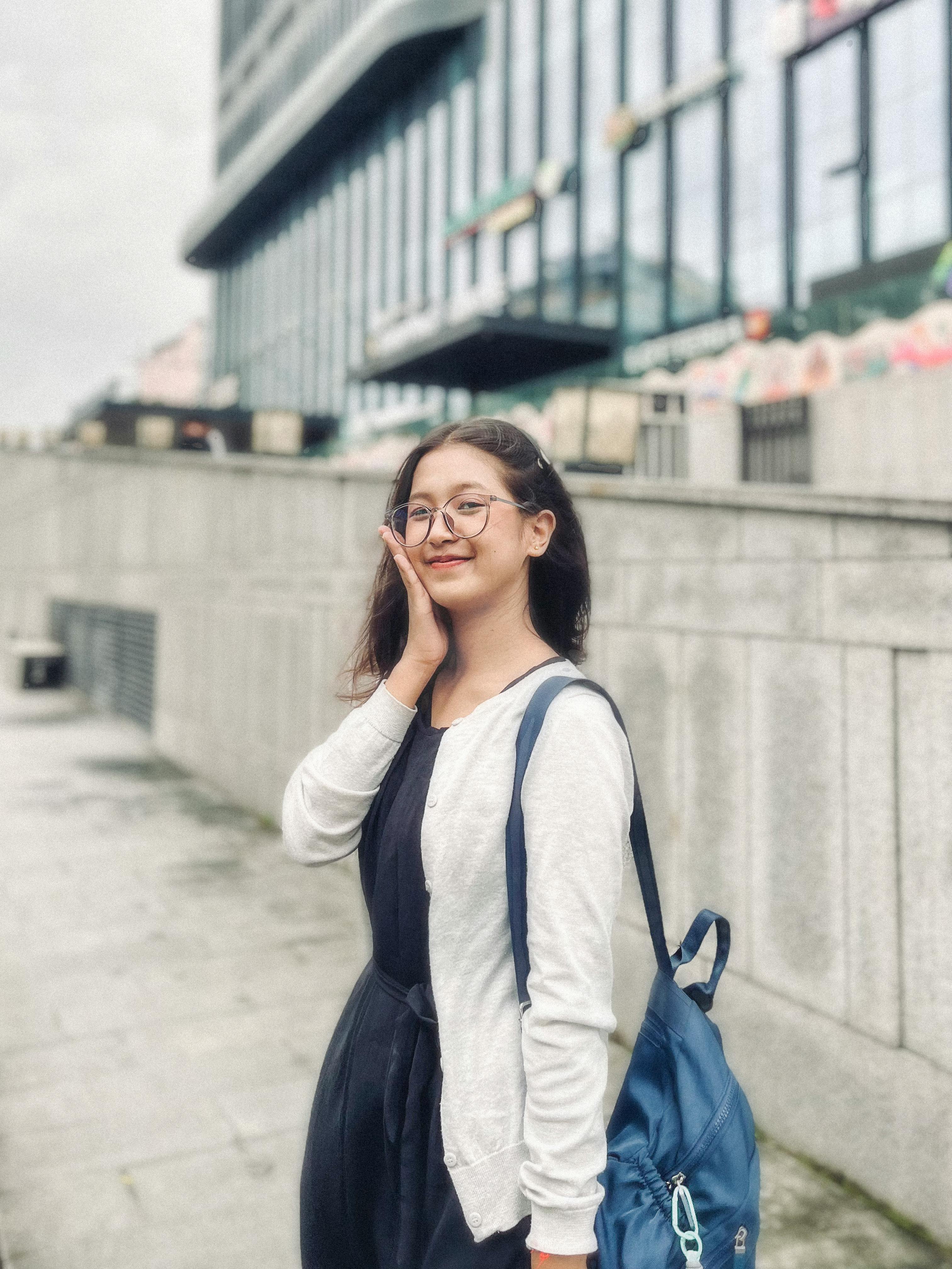 Smiling Young Woman with Backpack in Urban Setting