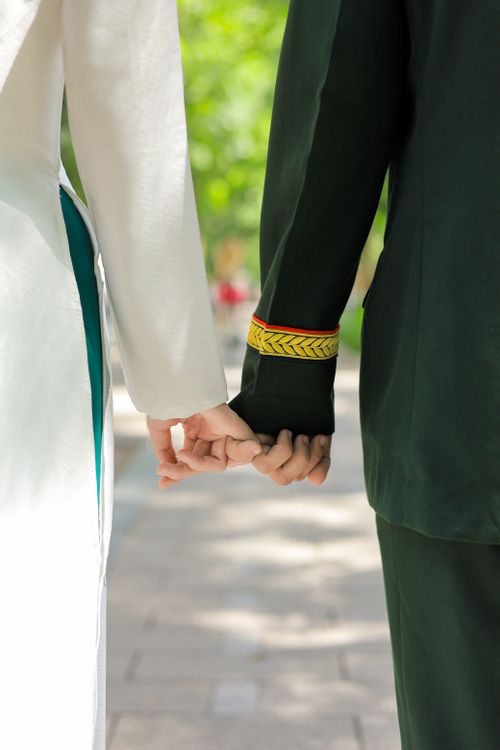 Free A couple holding hands in traditional Vietnamese attire, showcasing cultural heritage. Stock Photo