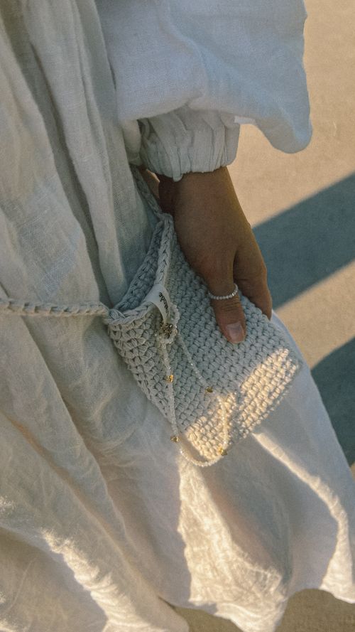 Hand holding a crocheted shoulder bag — photo by Viktorya Sergeeva on Pexels