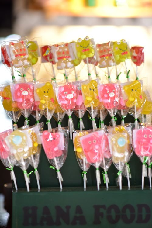 Free Brightly colored animal-shaped lollipops on display at a food stall. Stock Photo