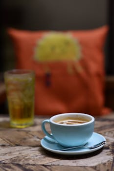 Warm cozy cafe atmosphere with a cappuccino and iced drink on a wooden table.