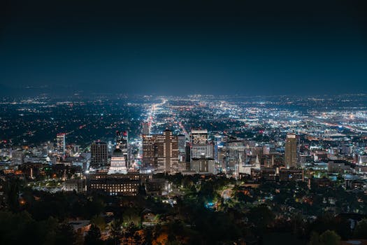Beautiful nighttime aerial shot of Salt Lake City skyline with illuminated city lights and clear sky.