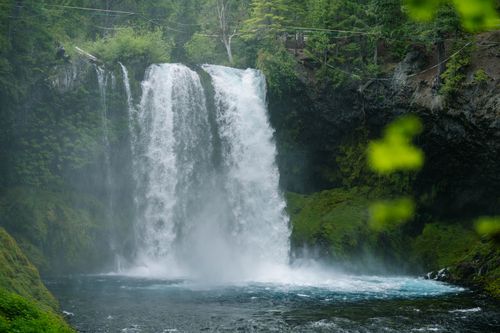 Free A breathtaking waterfall cascades into a serene pool in a lush forest setting, perfect for nature enthusiasts. Stock Photo