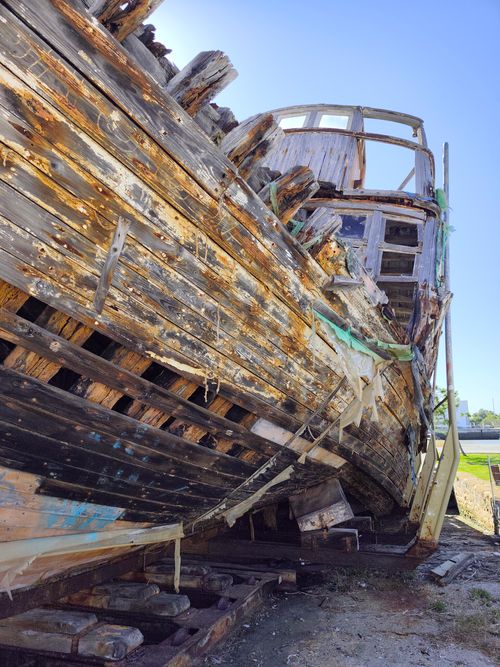 Free A weathered and abandoned wooden boat on a sunny day in El Puerto de Santa María. Stock Photo