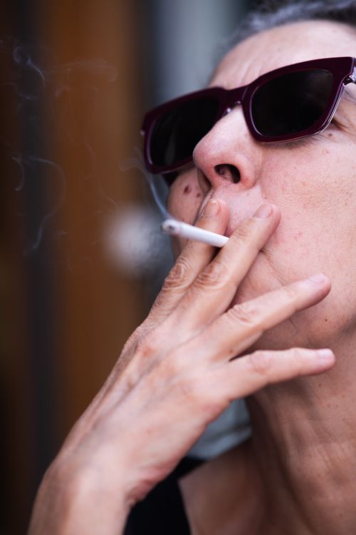 Free Close-up of a senior woman smoking a cigarette outside in İzmir, Türkiye. Stock Photo