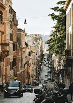意大利罗马的一条城市街道充满活力，两旁建筑物林立，车辆川流不息，捕捉了城市生活的精髓
