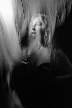 A surreal and ethereal black and white portrait of a woman in a flowing, dreamlike setting.