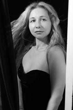 Black and white portrait of an elegant woman with flowing hair wearing a strapless dress.