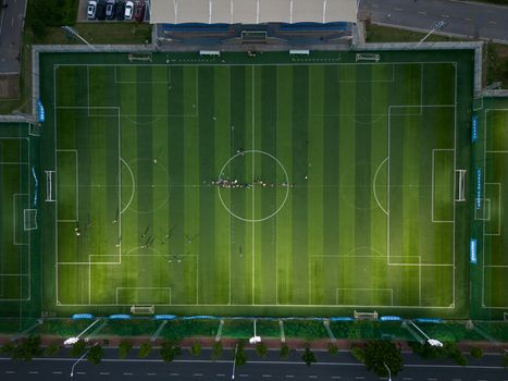 Top-down view of a soccer field with players during a daytime match.