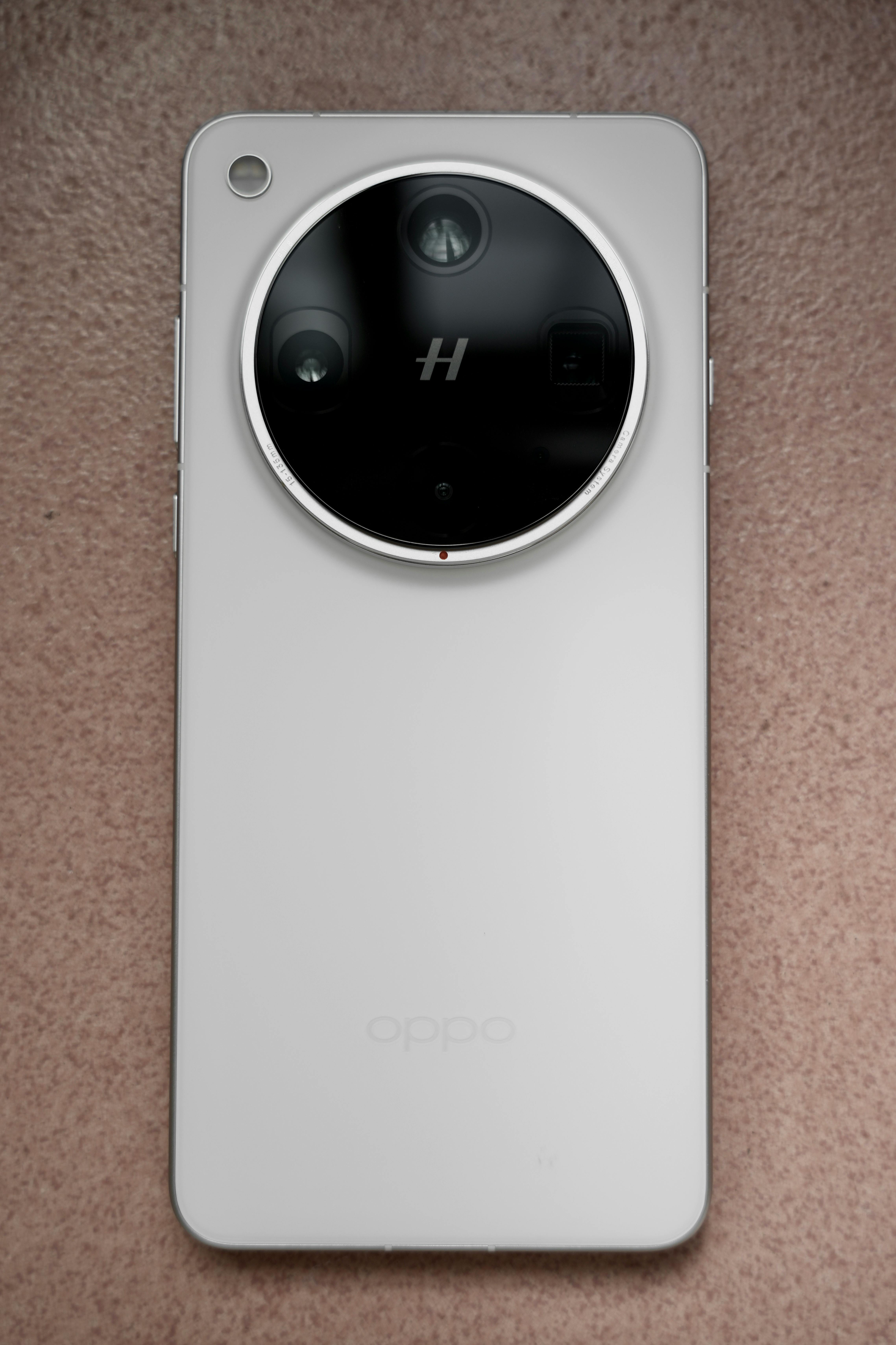 White smartphone with circular camera design on a textured surface.