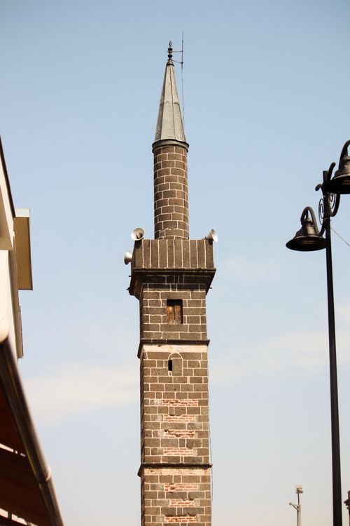 Free A tall stone minaret set against a clear blue sky, showcasing historic architecture. Stock Photo
