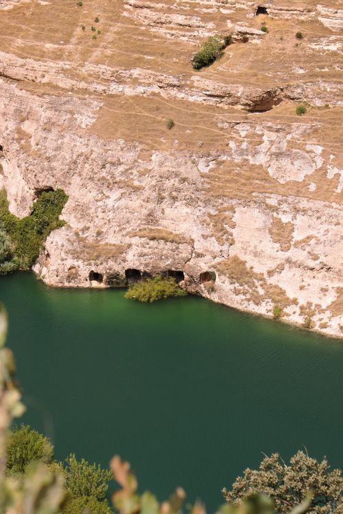 Free Breathtaking view of a turquoise lake bordered by rugged cliffs under a clear sky. Stock Photo