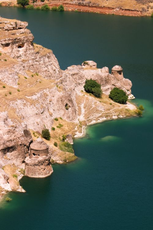 Free Aerial view of historical fort ruins on rocky cliffs by calm blue waters. Stock Photo