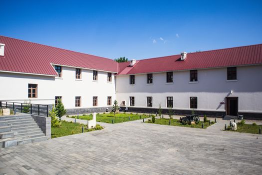 A contemporary building with a red roof in Tunceli, Türkiye under clear blue skies.