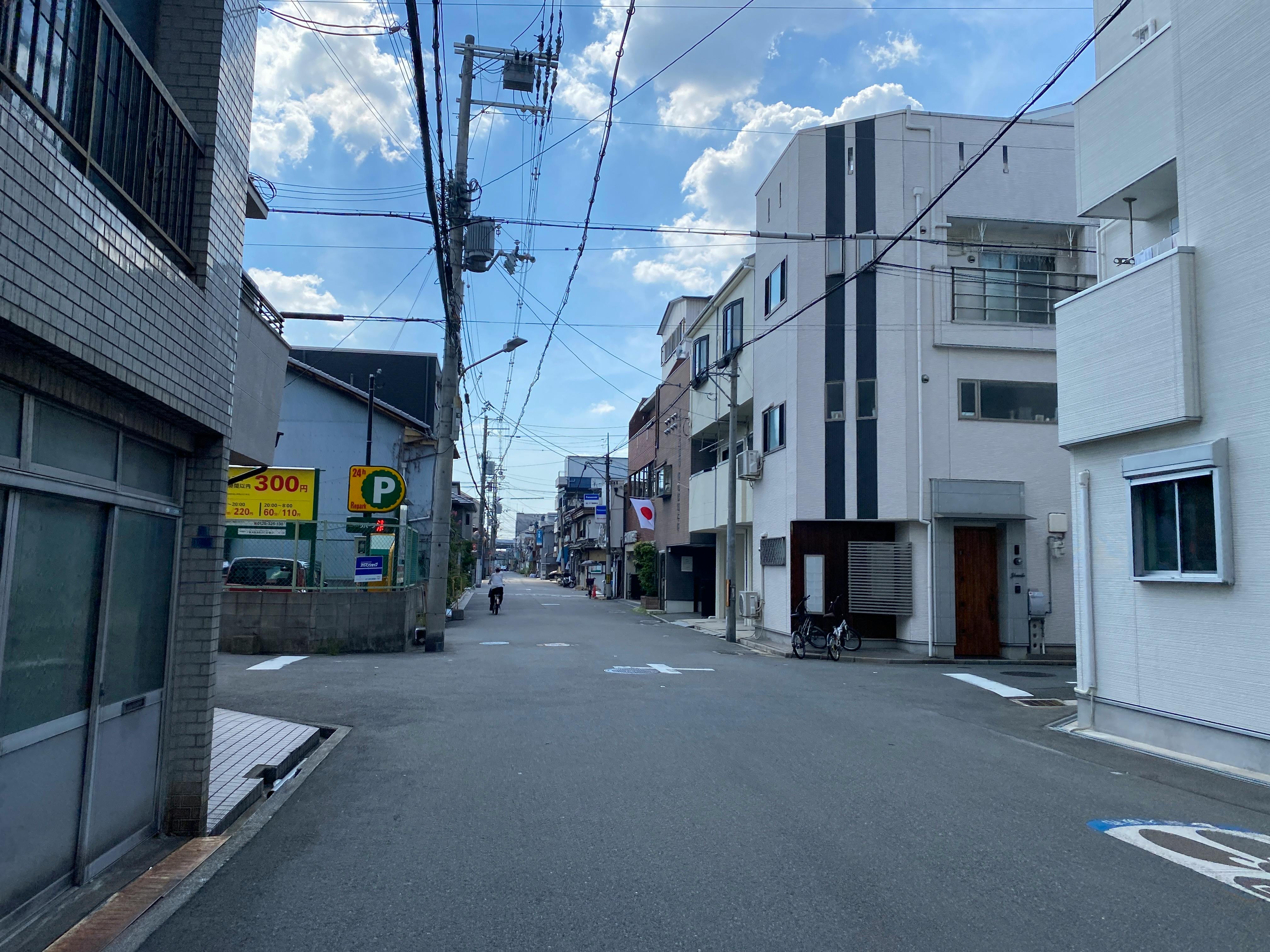 近代的な建物と青い空のある日本の近所の空いている通り。