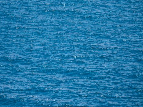 Capture of a vibrant blue ocean with gentle waves under bright daylight, showcasing the beauty of nature.