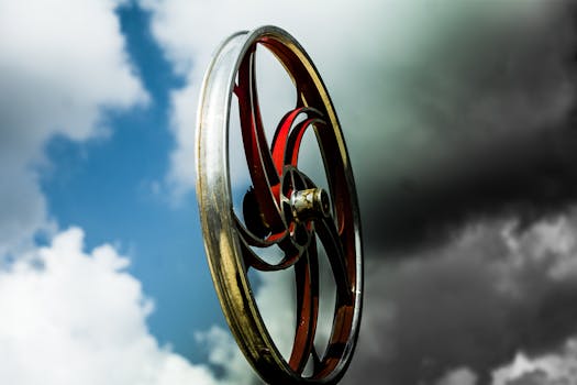 A captivating image of a vintage metal wheel set against a dramatic cloudy sky capturing an industrial aesthetic.