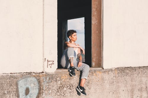 Free Photo Of Woman Sitting On Concrete Surface Stock Photo