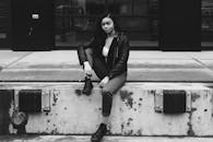 一张时尚的黑白照片中，一位年轻女子在城市环境中摆着姿势