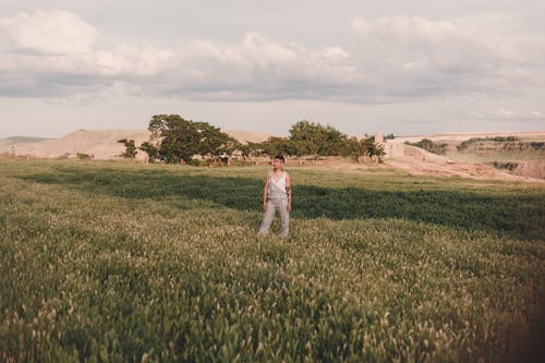 Женщина, стоящая на траве поля