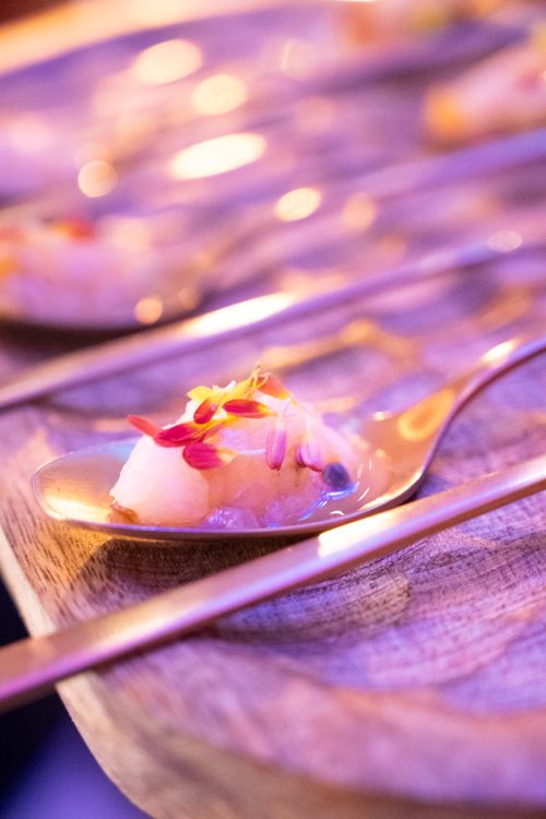 Free Gourmet dish with edible flowers on a silver spoon, highlighting artistic food presentation. Stock Photo