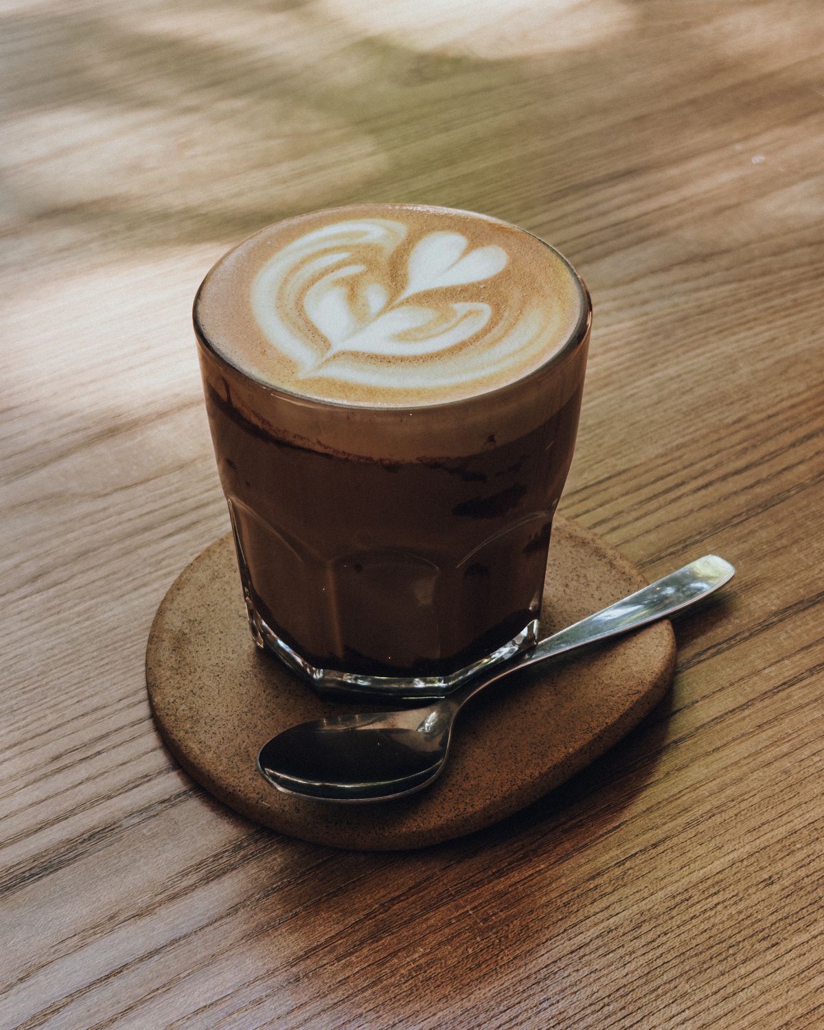 Cortado with latte art on a wooden table