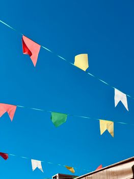 Vibrant bunting flags hanging under a clear blue sky, creating a festive atmosphere.