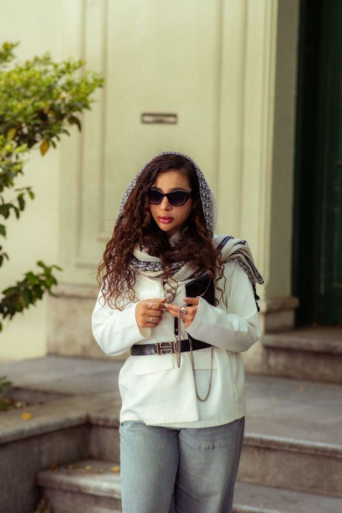 Free Stylish young woman with sunglasses and headscarf, posing on urban steps. Stock Photo