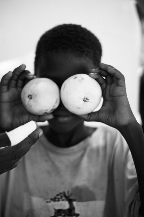 Free A child playfully holds oranges up to their eyes, creating a fun and joyful moment. Stock Photo
