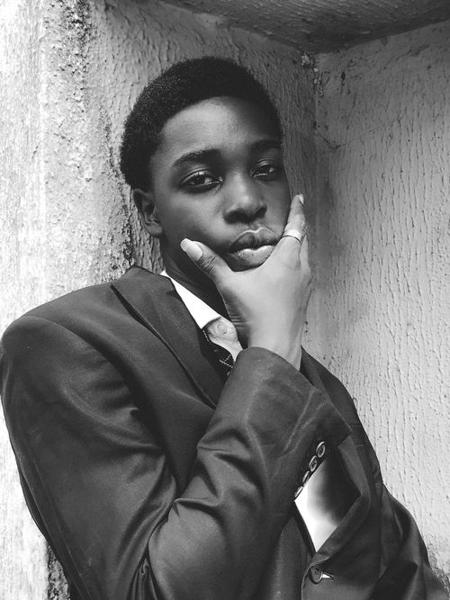 Free Close-up black and white portrait of a young man in a suit, deep in thought. Stock Photo