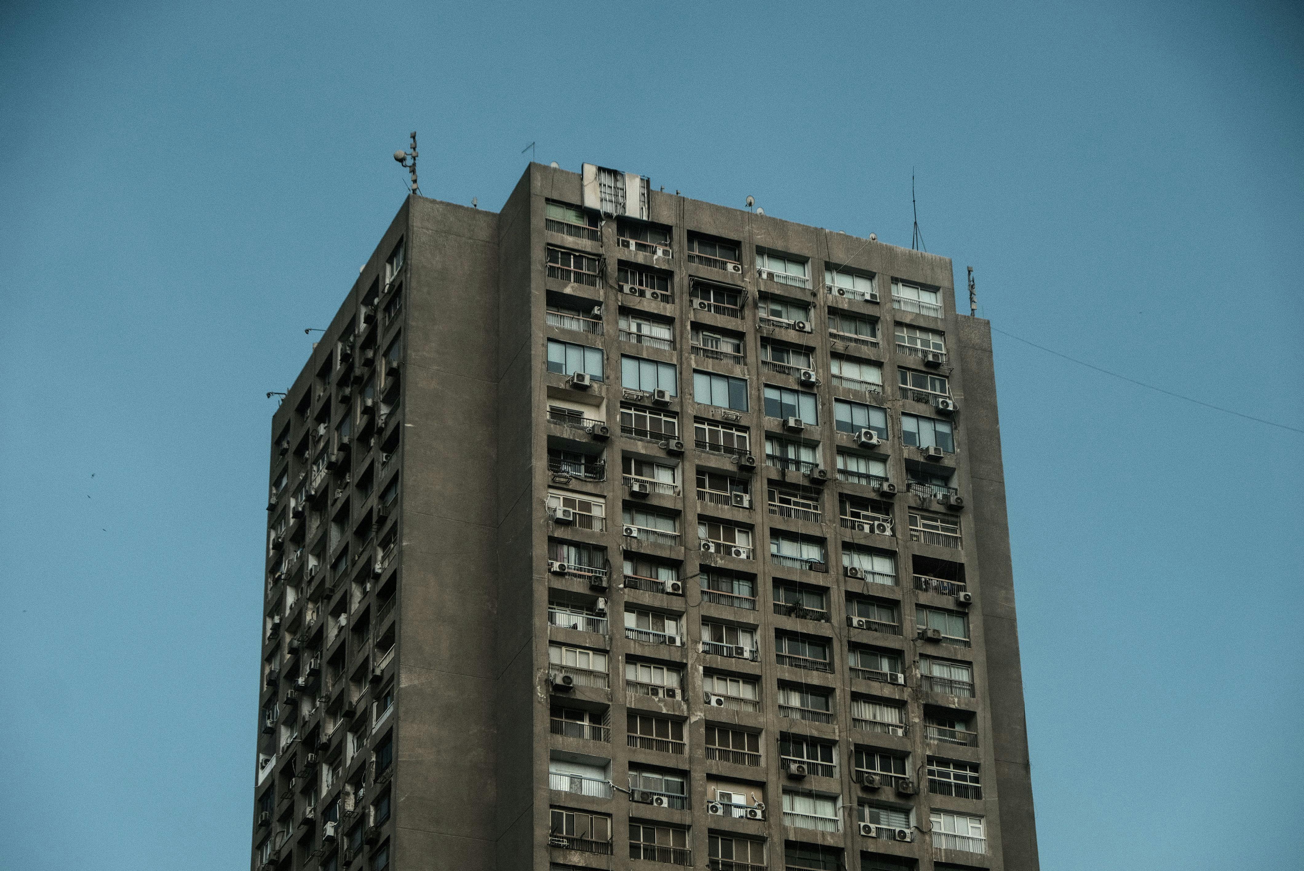 Gratis Et vintage brutalistisk tårn med forvitret betonfacade mod en klar blå himmel i Kairo, Egypten. Lagerfoto