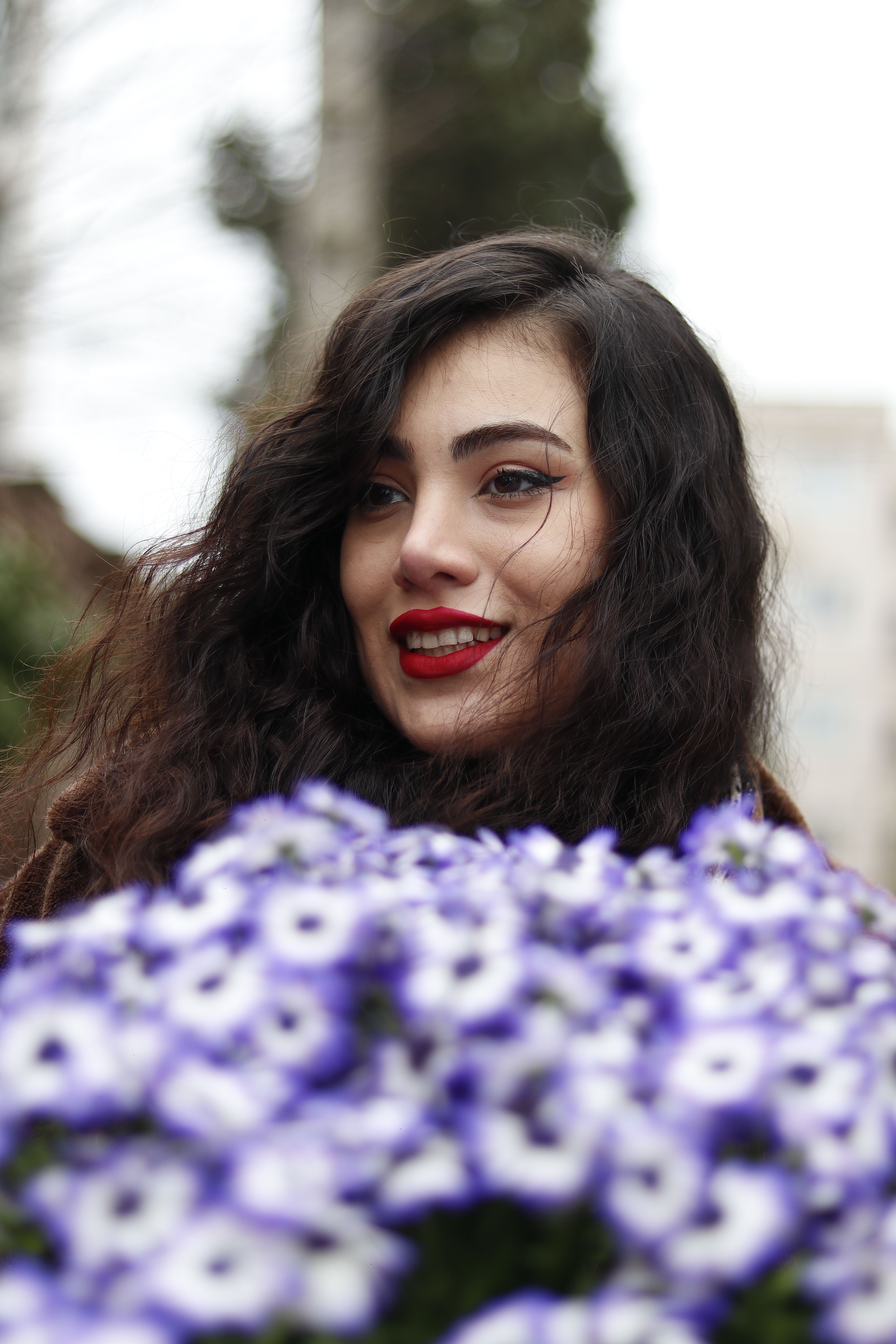 Elegant portrait of a young woman with violet flowers, captured in Tehran.