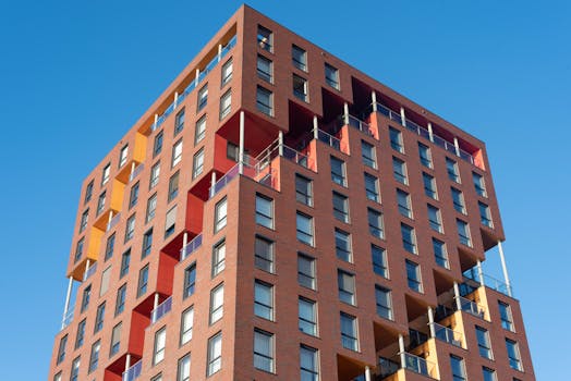 Contemporary architecture of a red brick apartment building under a blue sky in Maassluis, Netherlands.