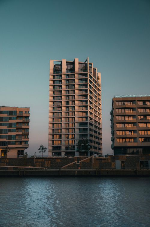 Free Contemporary apartment towers reflecting in calm waters during twilight, showcasing modern architecture. Stock Photo