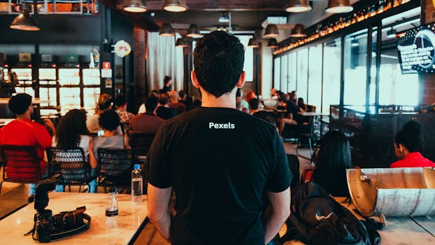 Back view of a seminar taking place in a modern indoor setting with diverse attendees.
