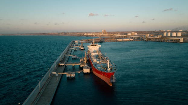 Stunning aerial shot of a docked cargo ship at an industrial port during sunset.