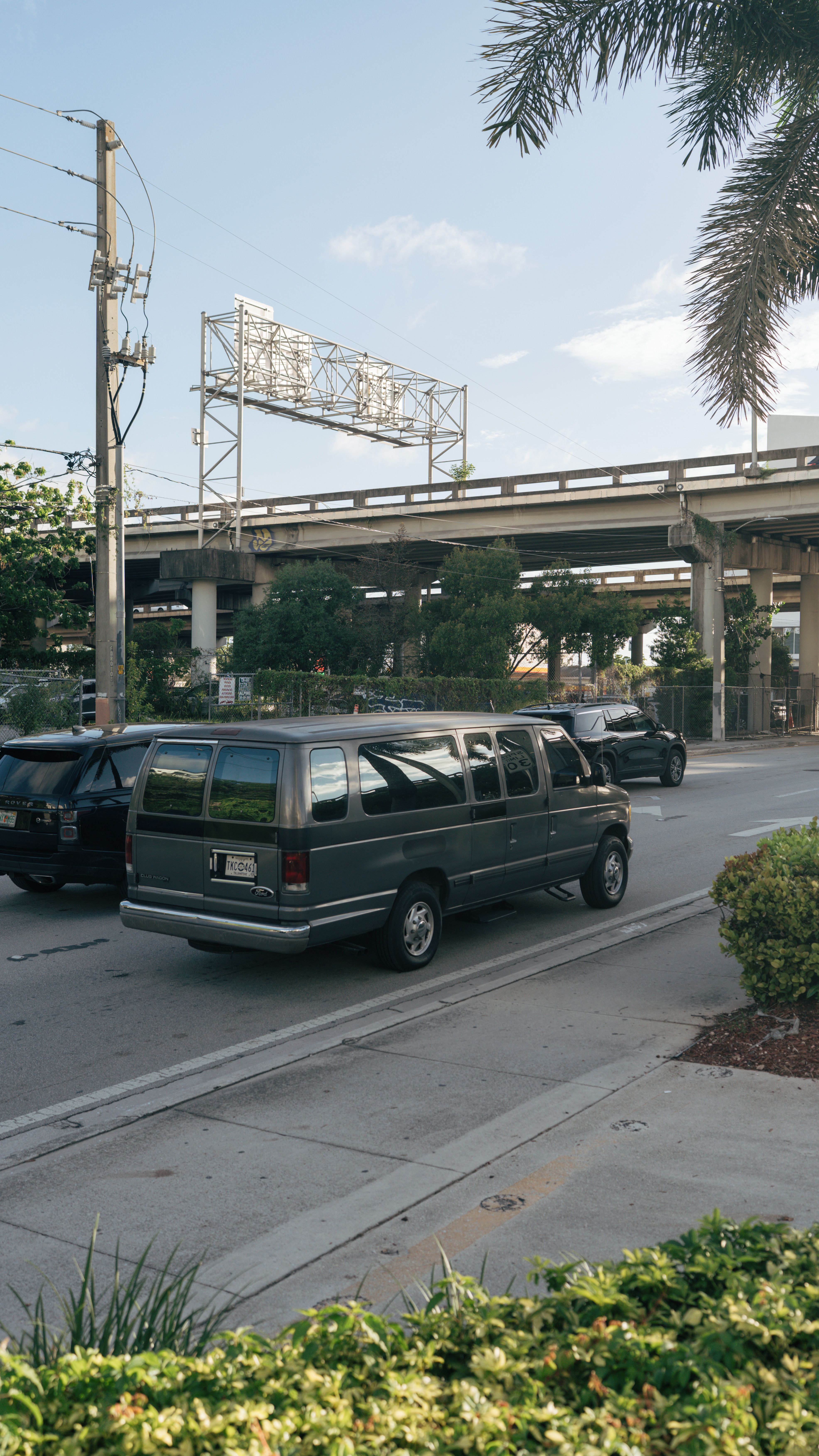 City street with cars and overpass, showcasing urban life and infrastructure.
