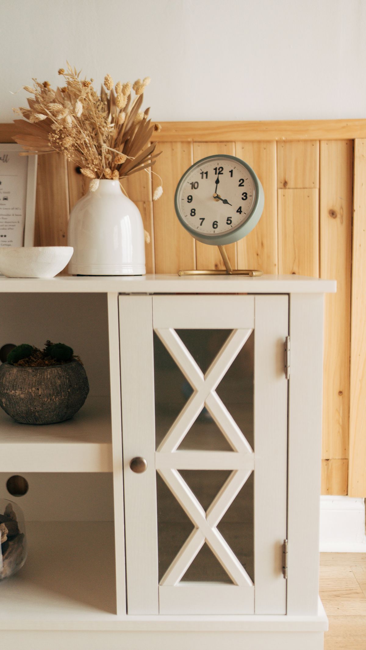 Scandinavian style shelf with a clock and decor in a cozy living room