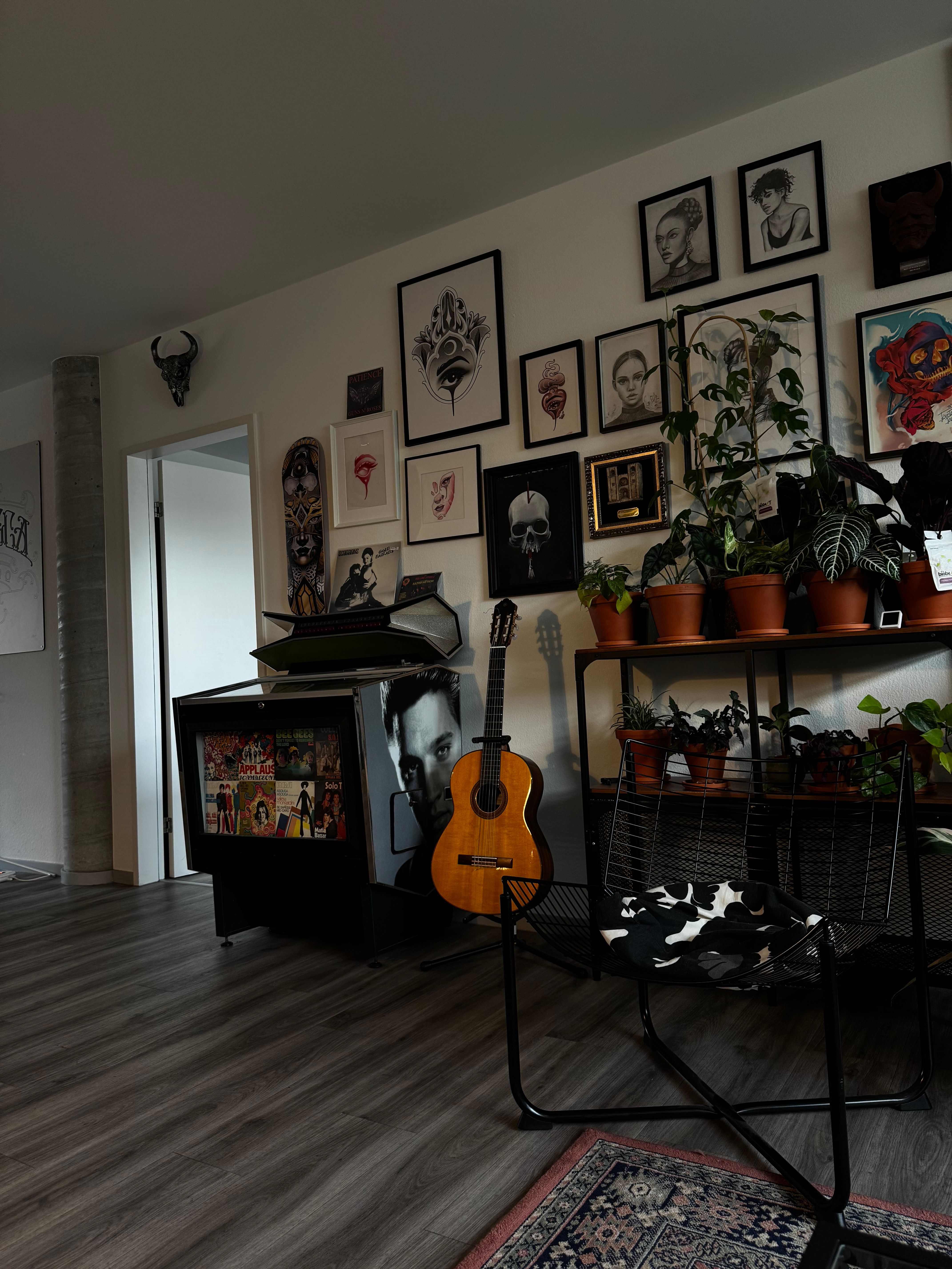 Stylish living room with guitar, art decor, and indoor plants, offering modern aesthetic.